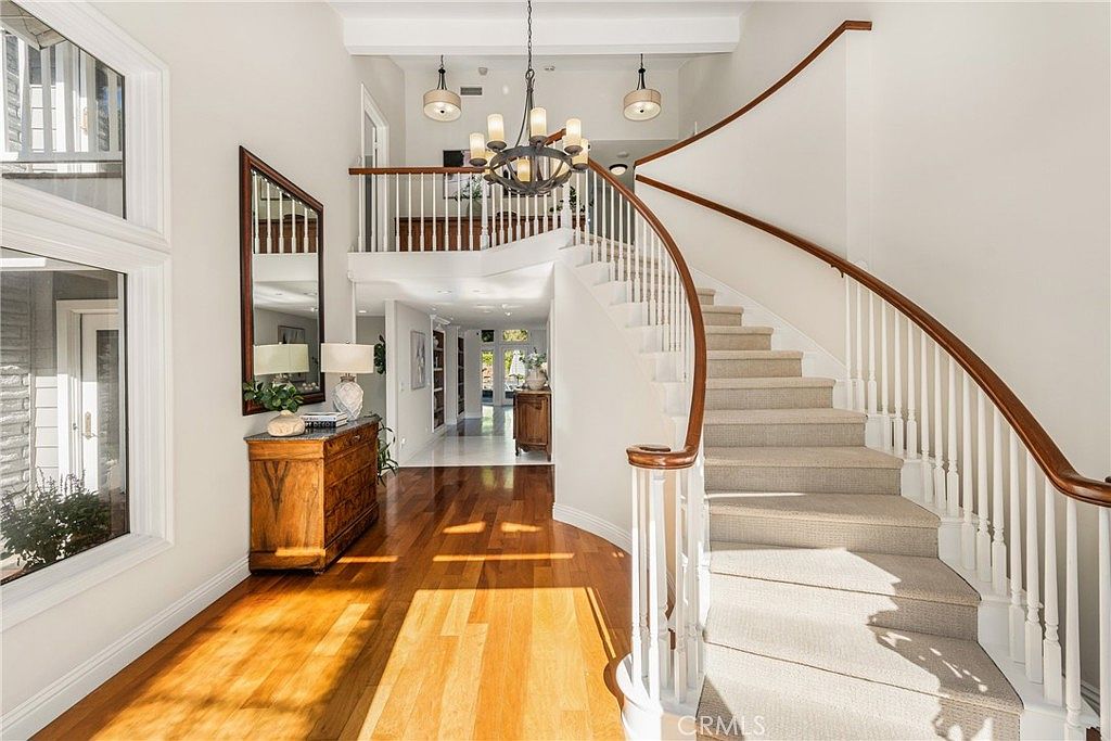 Dramatic two-story foyer with curved staircase and oak floors