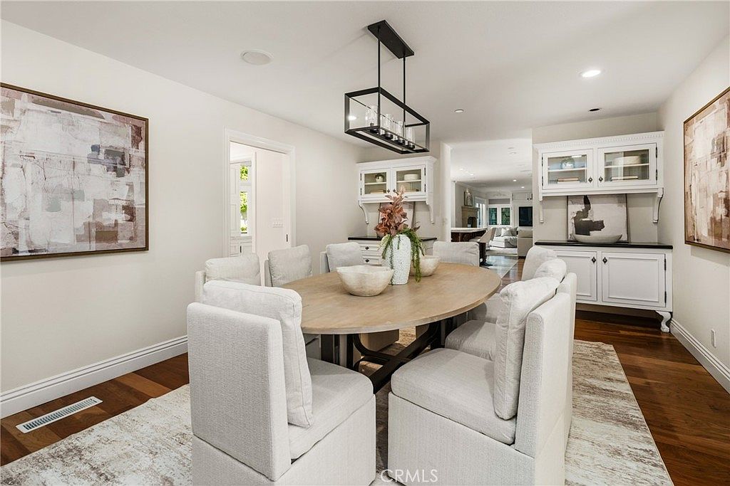 Formal dining room with linear chandelier and built-in cabinetry