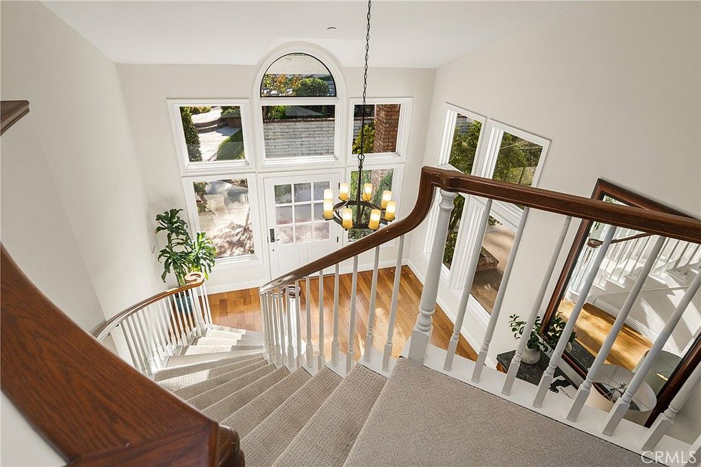 Stair landing with arched window and chandelier