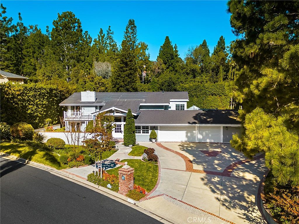 Aerial view of a traditional estate framed by mature trees in Cowan Heights, North Tustin